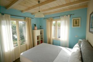 a bedroom with a white bed and two windows at Seaside Cottage in Kato Daratso