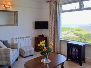 a living room with a vase of flowers on a table at Polmeor in Polzeath