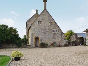 an old stone building with a driveway in front of it at Churchill Cottage in Holwell