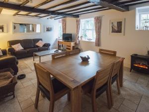 een woonkamer met een houten tafel en een bank bij Barbican Cottage in Middleham