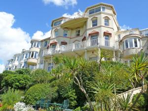 um grande edifício branco com árvores em frente em Cockington Bay Fort em Torquay