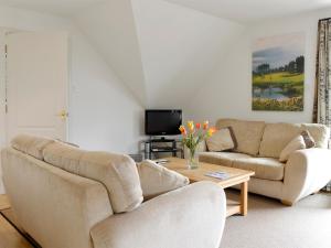 a living room with two couches and a tv at 22 Queens Court in Inchmarlo