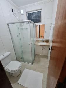 een badkamer met een douche, een toilet en een wastafel bij apartamento completo in Contagem
