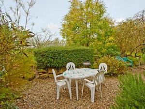 a table and four chairs in a garden at Holy Boys - 17626 in Castle Acre