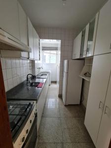 a kitchen with a sink and a refrigerator at apartamento completo in Contagem