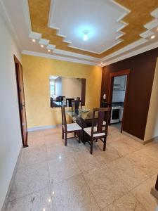 a dining room with a table and chairs and a kitchen at apartamento completo in Contagem