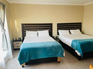 two beds in a room with two beds sidx sidx sidx at Druza’s guest house in Rustenburg