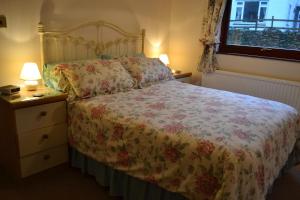 a bedroom with a bed and a dresser and a window at Briarwood in Bowness-on-Windermere