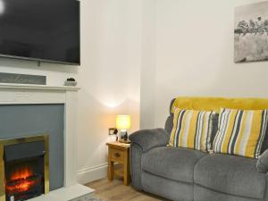 a living room with a couch and a fireplace at Hidden Gem Cottage in Great Driffield