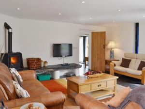 a living room with a couch and a fireplace at Y Stabl in Llanwrda