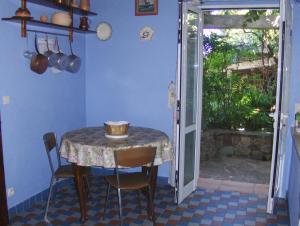een tafel en stoelen in een kamer met een tafel en een raam bij Gite sur les collines de mandelieu in Tanneron
