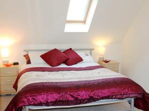 シャンクリンにあるSwallow Cottageのベッドルーム1室(大型ベッド1台、赤い枕付)