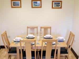 a dining room table with chairs and plates and glasses at Swallow Cottage in Shanklin