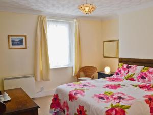 a bedroom with a large bed and a window at Sundowners in Calstock