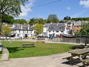 a park with benches and buildings in a town at Sundowners in Calstock