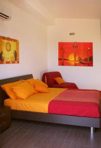 1 dormitorio con 1 cama con almohadas de color naranja en Nacional B&B, en Monforte San Giorgio Marina