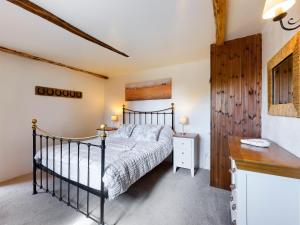 a bedroom with a bed and a wooden wall at The Old Coach House in Iddesleigh
