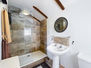 a bathroom with a sink and a toilet and a shower at The Old Coach House in Iddesleigh +11 photos