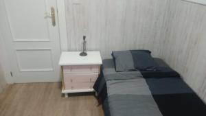 a small bedroom with a bed and a night stand at ARCHETYP in Torrejón de Ardoz