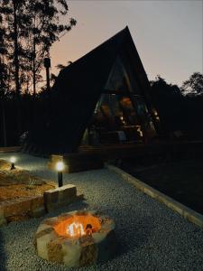 a fire pit in front of a house at night at Chalés Benessere in Lauro Müller