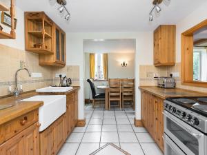 cocina grande con armarios de madera y mesa en Coach House, en Wareham