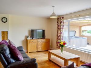 a living room with a couch and a tv and a table at Dolview in Penybont