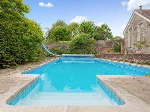 a swimming pool with blue water in a yard at Coach House in Wareham