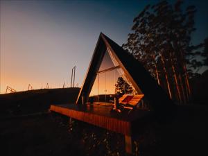 a small house with a glass roof at sunset at Chalés Benessere in Lauro Müller