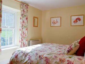 um quarto com uma cama e uma janela em 3 Highrake em Glenridding