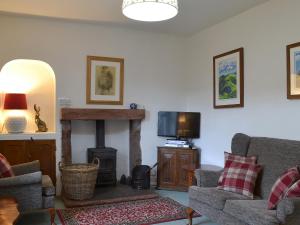 sala de estar con sofá y chimenea en 3 Highrake en Glenridding