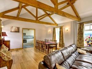 a living room with a leather couch and a table at Stable Cottage in Burythorpe