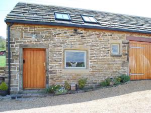 a brick house with a dog in a window at Appleshine Cottage in Almondbury