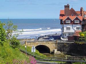 a house on a bridge next to the beach at Sunnyside in Sandsend