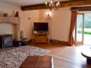 a living room with a flat screen tv and a fireplace at Lee Cottage in Heptonstall
