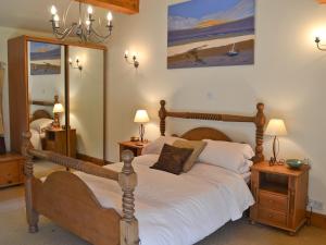 a bedroom with a large bed with white sheets at Lee Cottage in Heptonstall