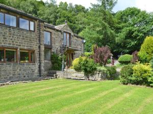 a stone house with a lawn in front of it at Lee Cottage in Heptonstall