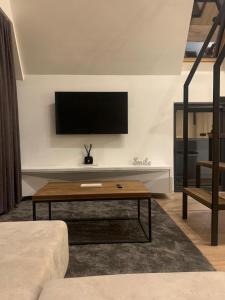 ein Wohnzimmer mit Fernseher und Couchtisch in der Unterkunft ICON APARTMENTS in Kopaonik