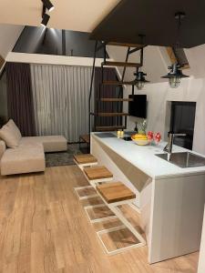 eine Küche mit einer weißen Theke und ein Wohnzimmer in der Unterkunft ICON APARTMENTS in Kopaonik