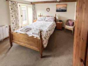 1 dormitorio con cama con marco de madera y ventana en Dragonfly 3, en North Newton