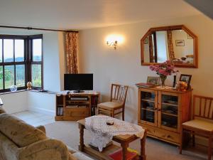 a living room with a couch and a tv at Hideaway in Brompton Ralph