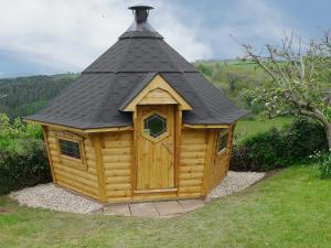 une petite cabane en bois avec un toit noir dans l'établissement Hideaway, à Brompton Ralph