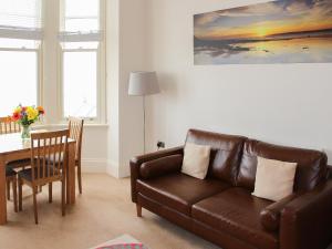 a living room with a couch and a dining room table at Apartment 2 in Filey