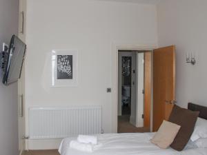 a bedroom with a white bed and a hallway at Apartment 2 in Filey