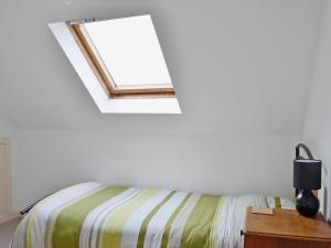 a bedroom with a bed and a window at Shore Cottage in Bellochantuy