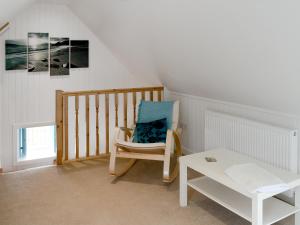 a white room with a chair and a table at Kates Croft in Portgower
