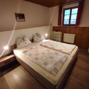 - une chambre avec un grand lit éclairé dans l'établissement Appartements Steffila, à Sand in Taufers