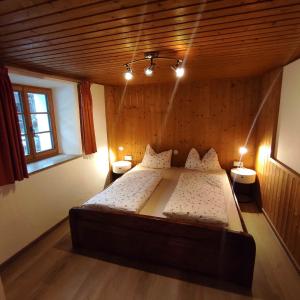 - une chambre avec un grand lit et 2 tables de chevet dans l'établissement Appartements Steffila, à Sand in Taufers