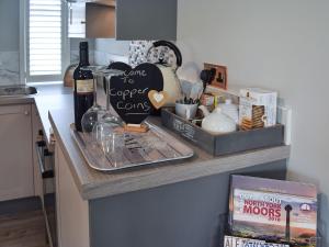 um balcão de cozinha com uma prateleira com uma garrafa de vinho em Copper Coins em Whitby