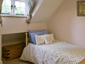 a bedroom with a bed and two windows at The Coach House in Aston Cantlow