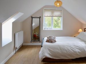 1 dormitorio con cama, ventana y espejo en Mill Haven, en Dunster